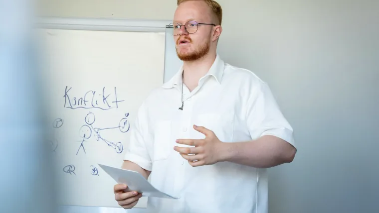 Simon Kröner erklärt an einem Whiteboard einen Prozess als Symbol für klare Abläufe auf Websites