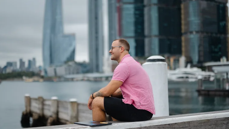 Per Starke sitzt mit Laptop am Wasser als ruhiges Bild für weniger mentale Last im Webdesign